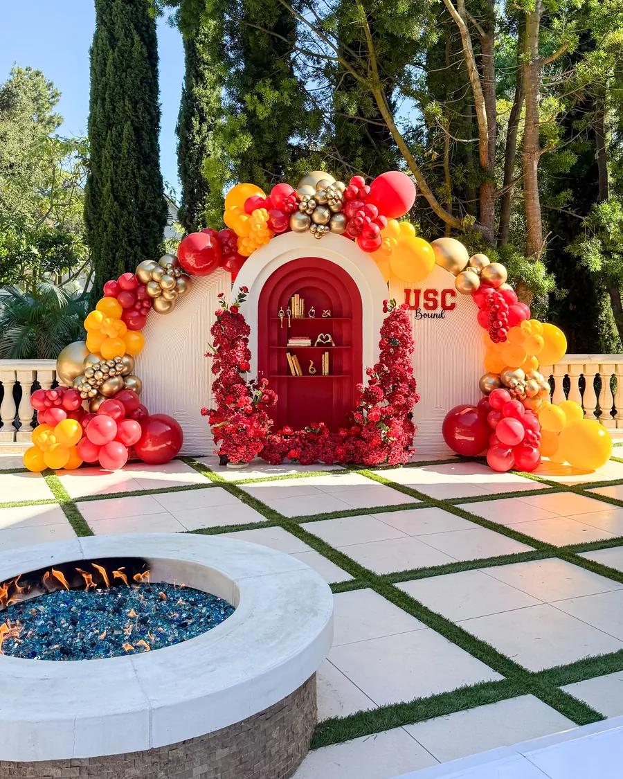 USC Bound graduation balloon arch installation with cream, red, and gold balloons at a Los Angeles event